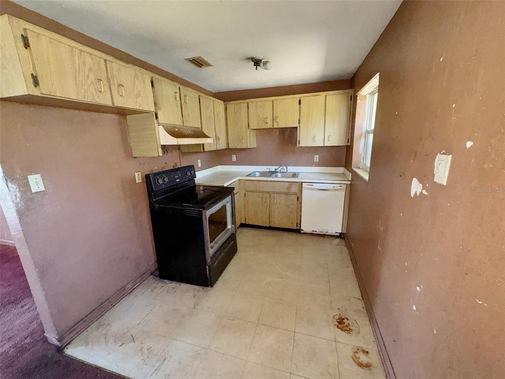 A kitchen with light wood cabinets, a black stove, and a white dishwasher — 2841 W AMELIA STREET, ORLANDO, FL