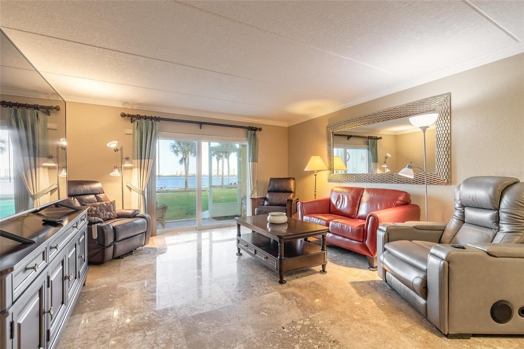 A living room features tile floors, a red sofa, two recliners, and a sliding glass door — 3131 S RIDGEWOOD AVENUE UNIT 101, SOUTH DAYTONA, FL