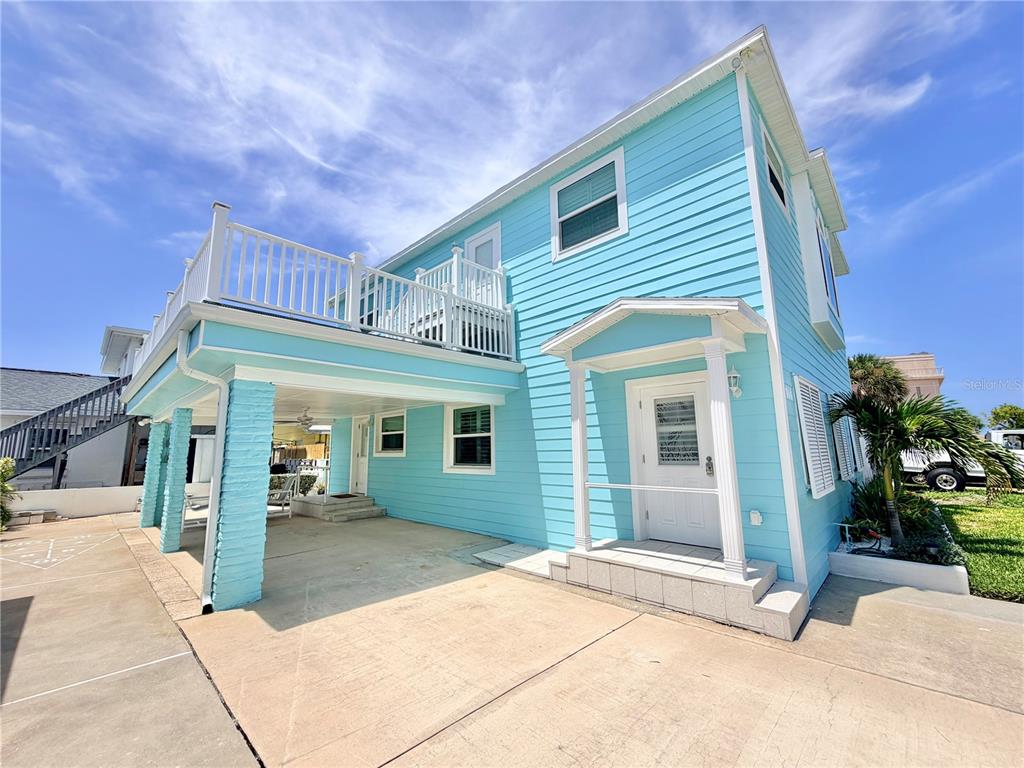 A light blue two-story house with a covered patio and an upper-level deck — 144 CORAL AVENUE, REDINGTON SHORES, FL