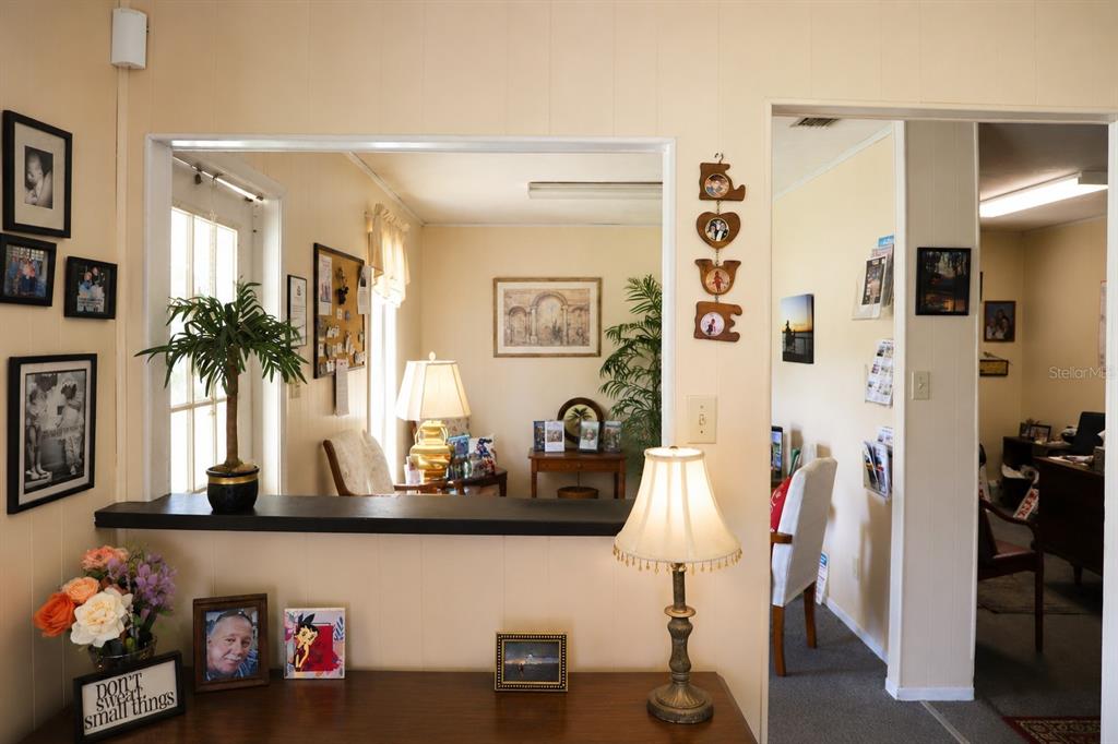 A view from a hallway looking into a living area through a large interior window — 7230 SE US HIGHWAY 301, HAWTHORNE, FL