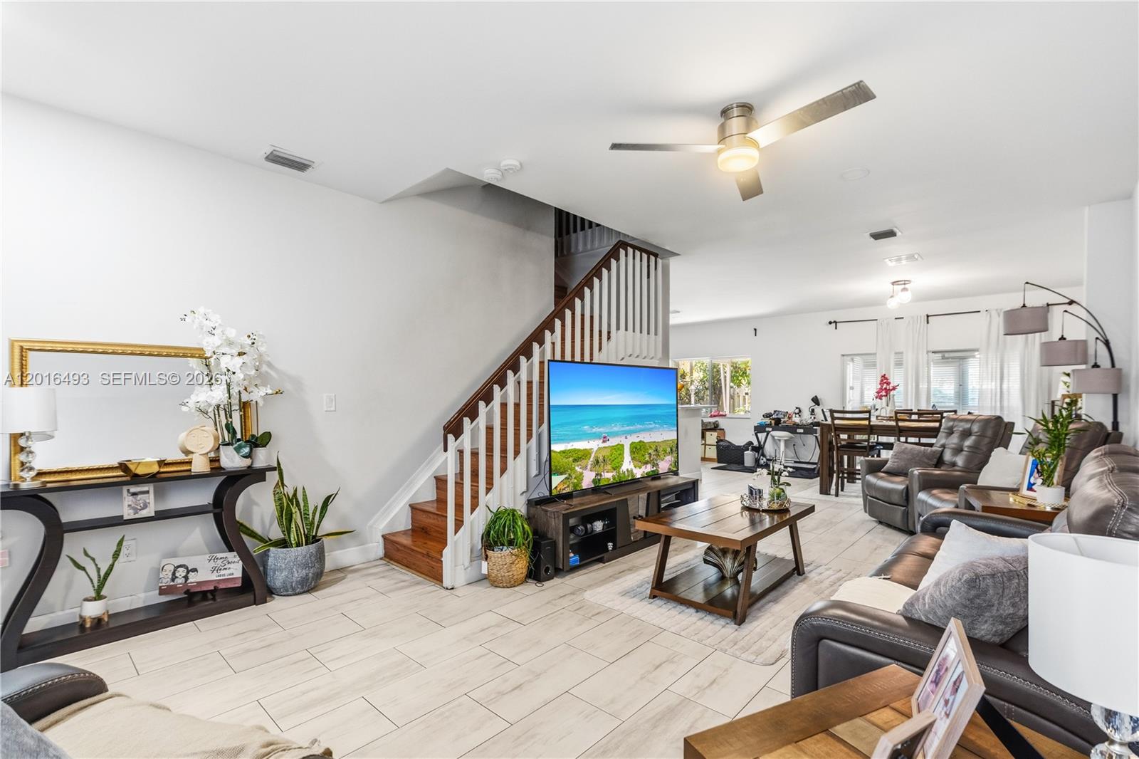 A living room features a staircase, a television on a console, and tiled flooring — 1844 SW 102nd Way, Miramar FL 33025, MIRAMAR, FL