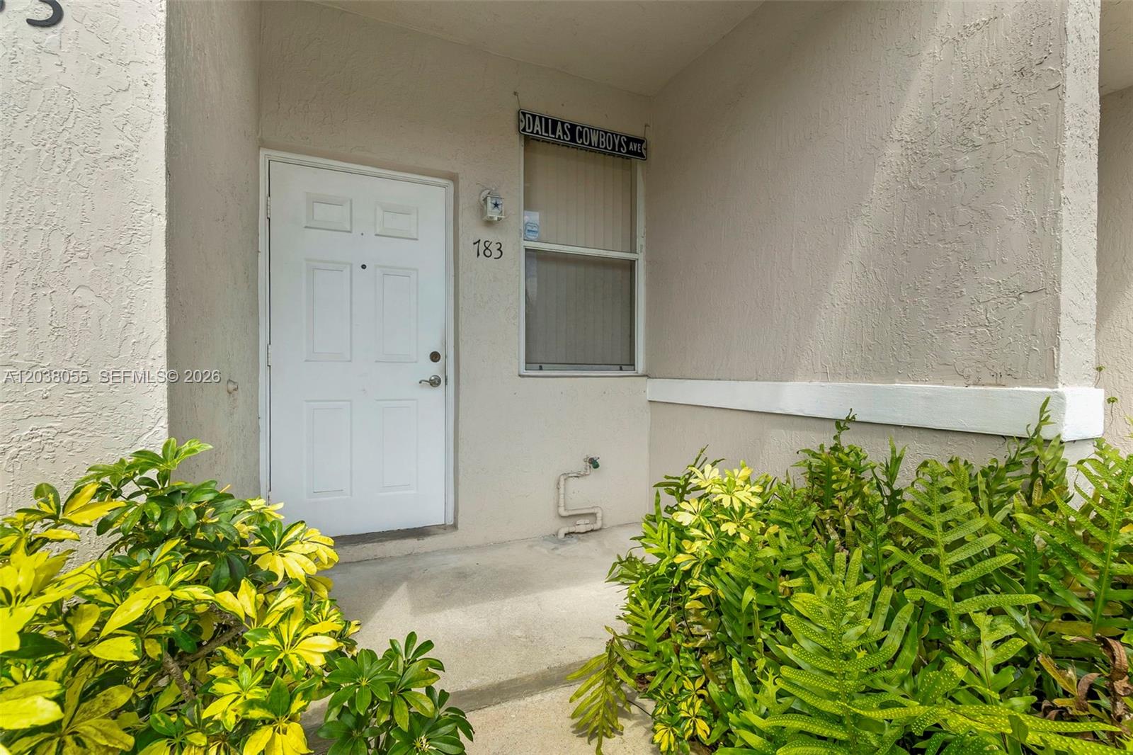 The exterior entrance features a white door, a window, and a Dallas Cowboys street sign — 783 NW 42nd Pl, Deerfield Beach FL 33064, DEERFIELD BEACH, FL