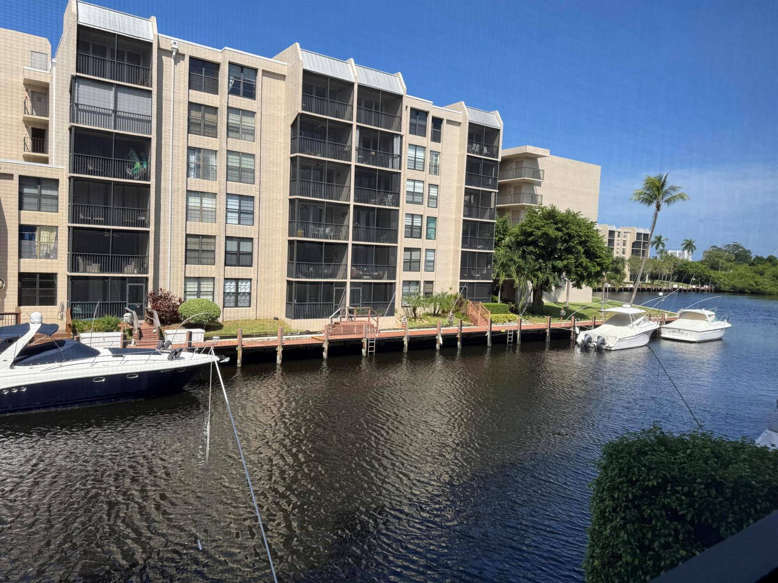 A multi-story apartment building sits along a canal with several boats docked at the bulkhead — 12 Royal Palm Way # 2050, Boca Raton FL 33432, BOCA RATON, FL