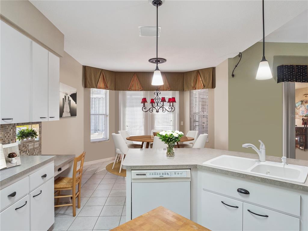 A kitchen with white cabinets, a breakfast nook, and a dining table with chairs — 6100 PRINCE FREDERICK COURT, LEESBURG, FL
