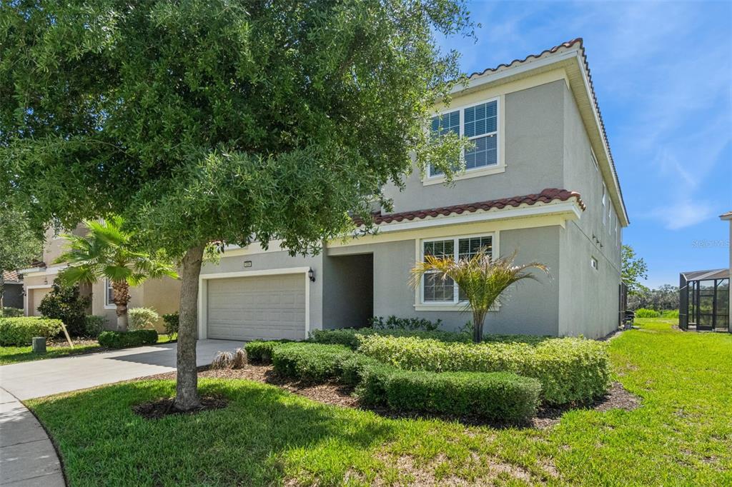 A two-story house with a gray stucco exterior, a two-car garage, and landscaped front yard — 5304 OAKBOURNE AVENUE, DAVENPORT, FL