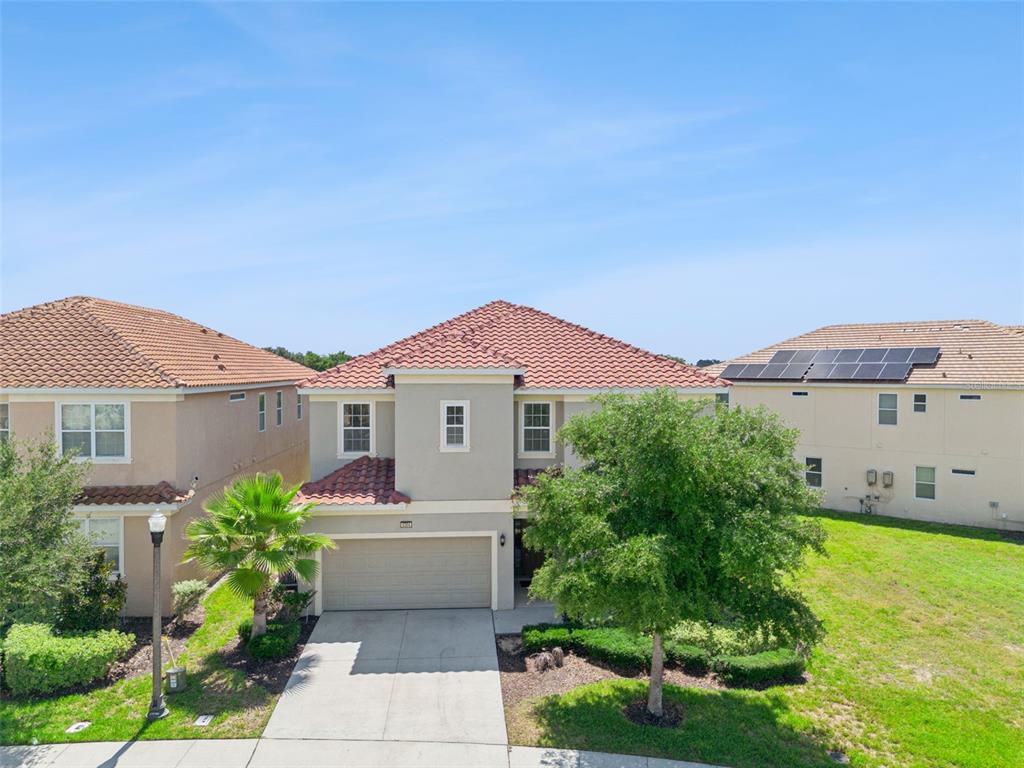 A two-story suburban house with a tile roof, a two-car garage, and a front yard — 5304 OAKBOURNE AVENUE, DAVENPORT, FL
