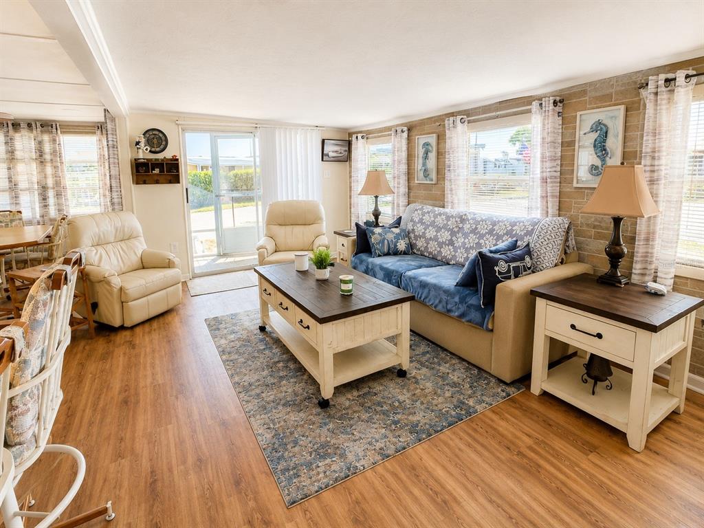 A living room features a blue sofa, a coffee table, two armchairs, and wood flooring — 6623 WASHINGTON STREET, BRADENTON, FL