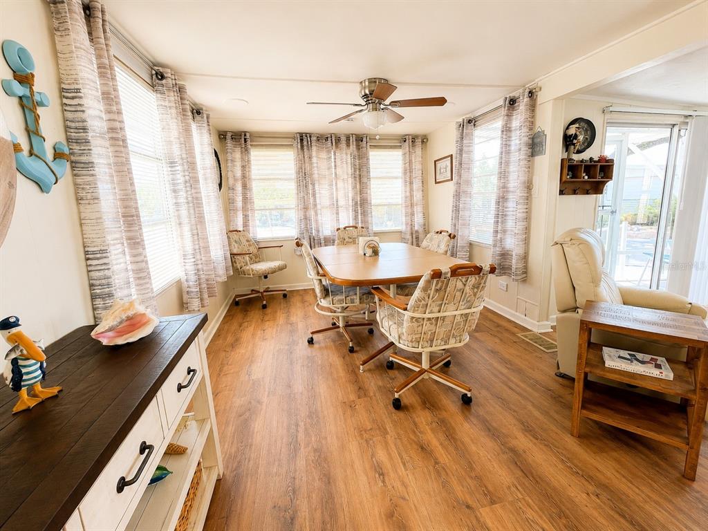A dining area with wood-look flooring, a table with four chairs, and large windows — 6623 WASHINGTON STREET, BRADENTON, FL