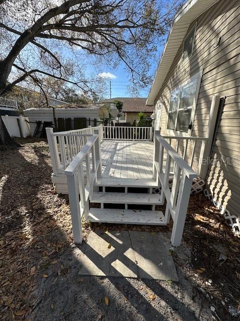 A white wooden deck with stairs leads to the side entrance of a house — 1587 SCRANTON AVENUE UNIT B, CLEARWATER, FL
