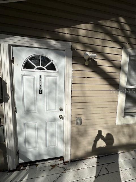 A white exterior door with a small window and the number 1587B is shown — 1587 SCRANTON AVENUE UNIT B, CLEARWATER, FL