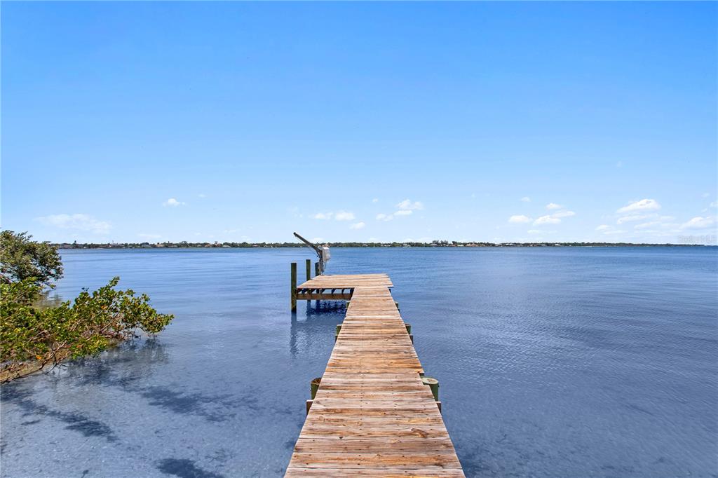 A wooden dock extends into a calm, blue body of water under a clear sky — 5216 13TH STREET, PALMETTO, FL