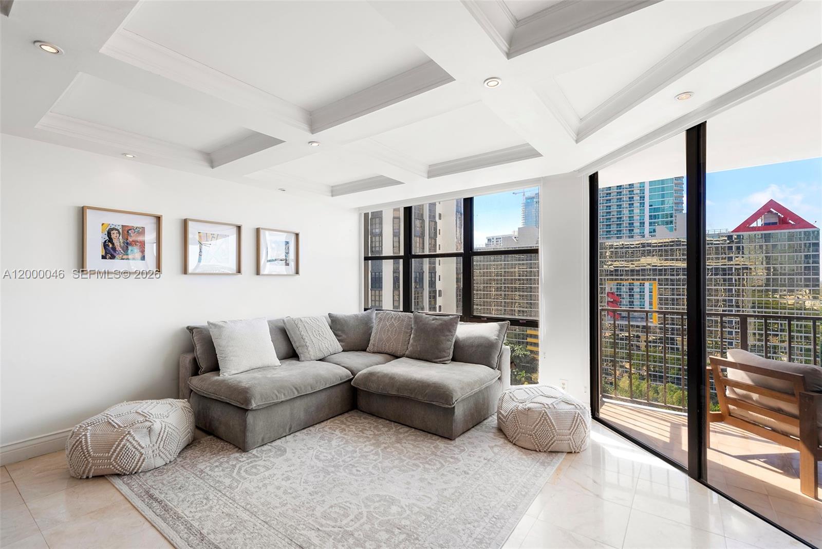 A living room features a grey sectional sofa, a patterned rug, and floor-to-ceiling windows — 1915 Brickell Ave # C1612, Miami FL 33129, MIAMI, FL