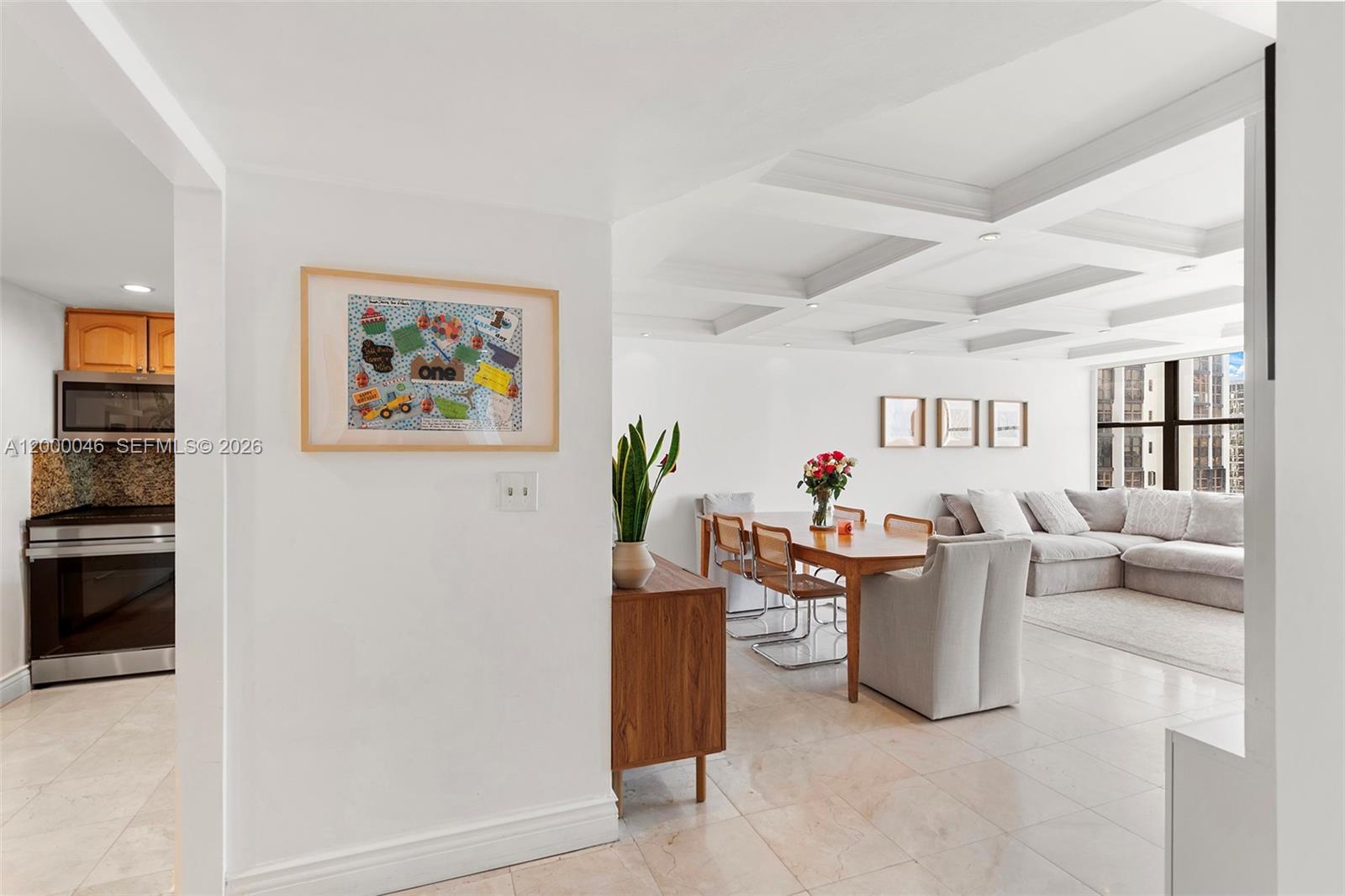 A dining area and living room feature a coffered ceiling and light tile flooring — 1915 Brickell Ave # C1612, Miami FL 33129, MIAMI, FL