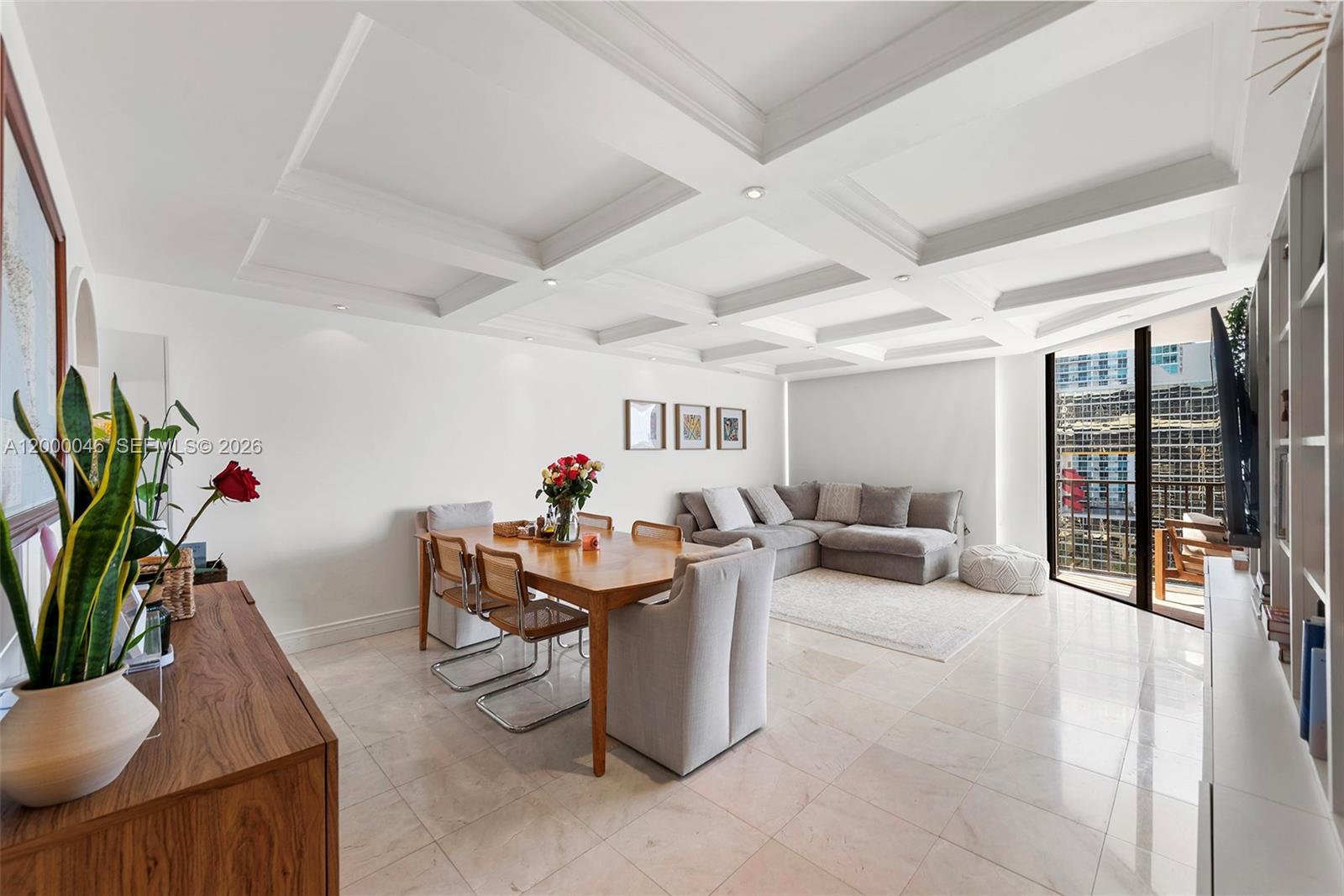 A living and dining room with a coffered ceiling, tile floors, and a balcony view — 1915 Brickell Ave # C1612, Miami FL 33129, MIAMI, FL
