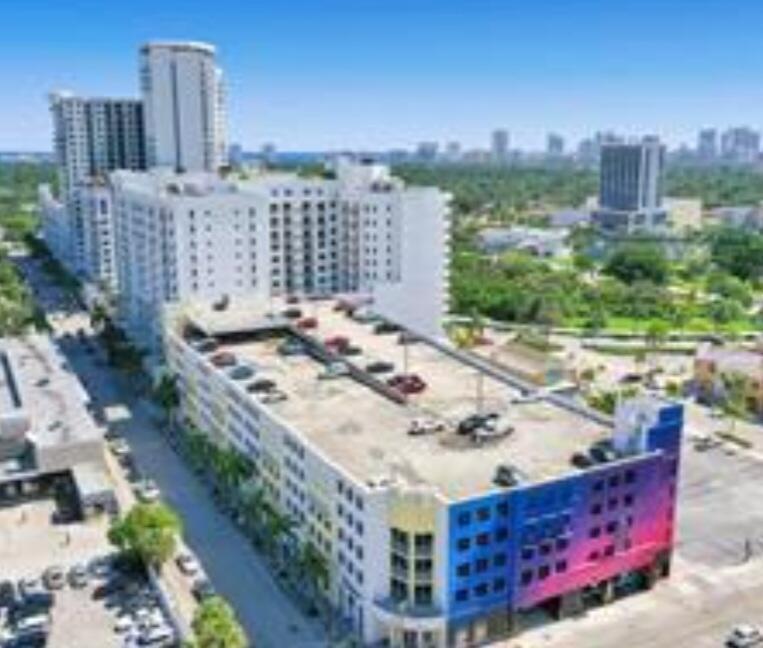 An aerial view of a multi-story parking garage with a colorful mural and surrounding buildings — 1830 Radius Drive # 526, Hollywood FL 33020, HOLLYWOOD, FL