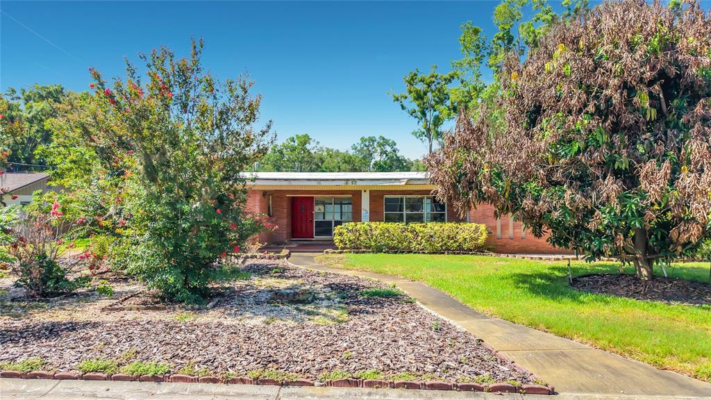 A single-story brick and siding house features a two-car garage and a front lawn — 605 COURTNEY DRIVE, TAMPA, FL