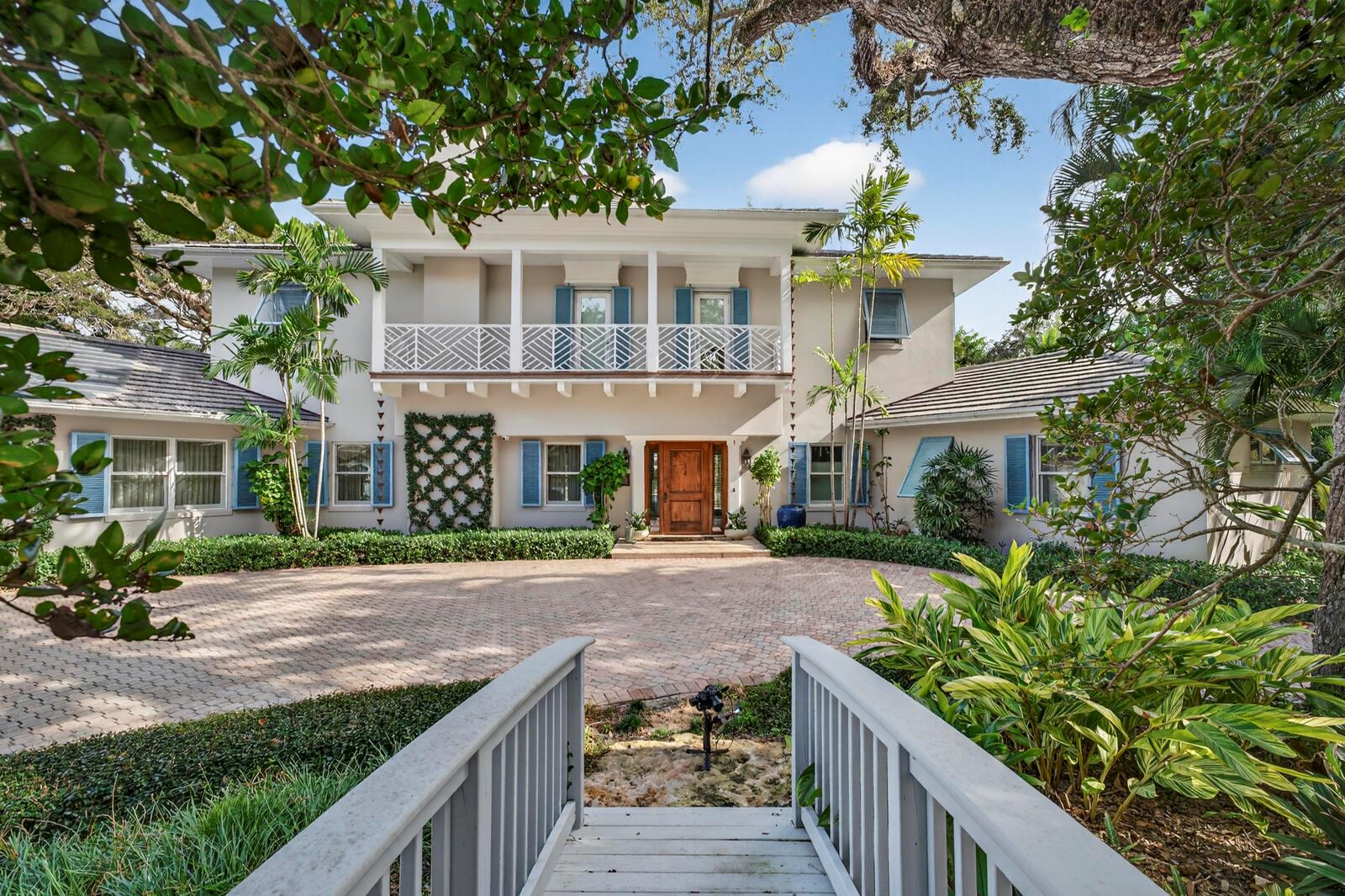A two-story house with a paved circular driveway and a wooden bridge in the foreground — 2010 Club Drive, Vero Beach FL 32963, VERO BEACH, FL