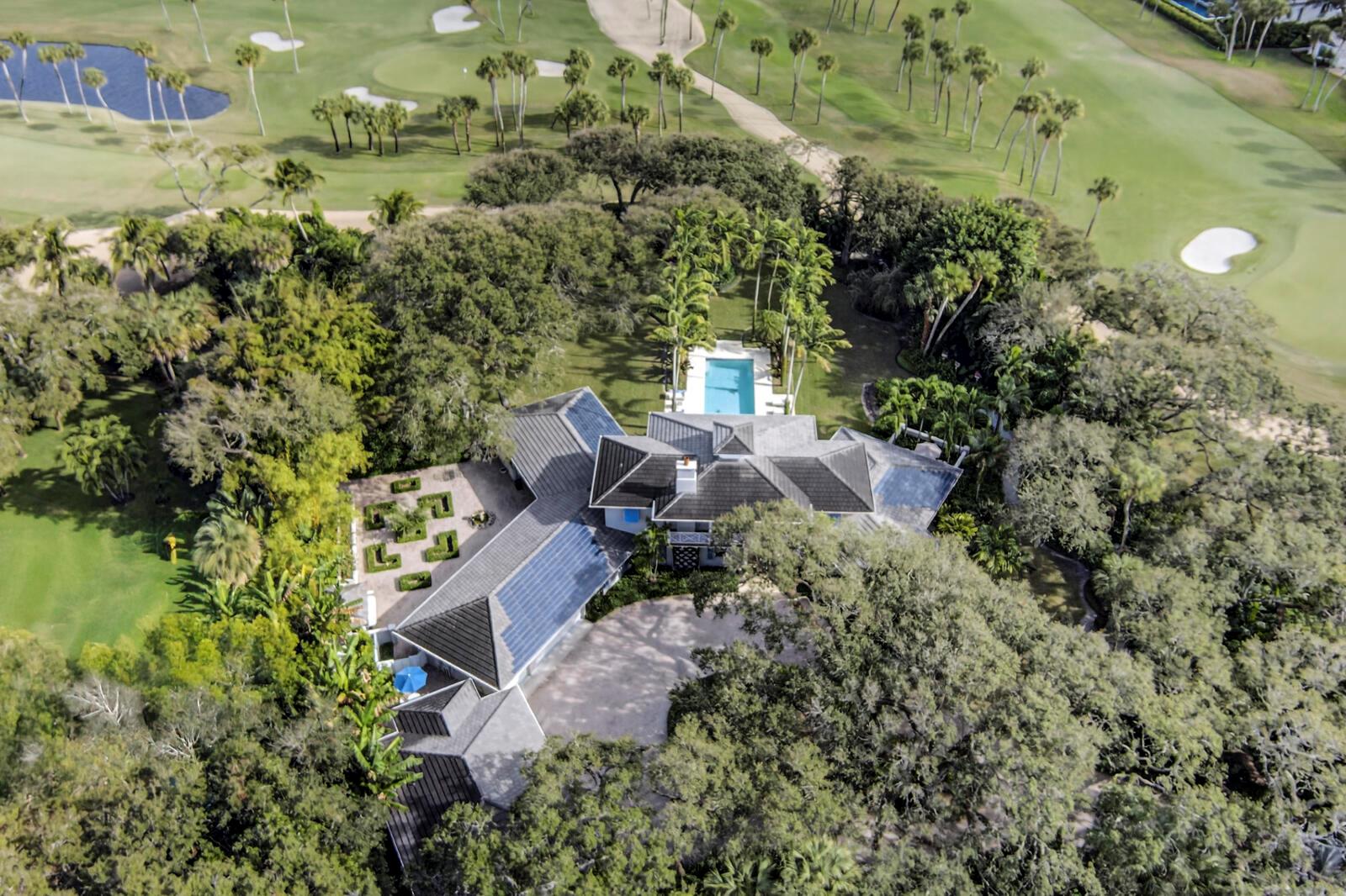An aerial view of a house with a swimming pool surrounded by trees and golf courses — 2010 Club Drive, Vero Beach FL 32963, VERO BEACH, FL