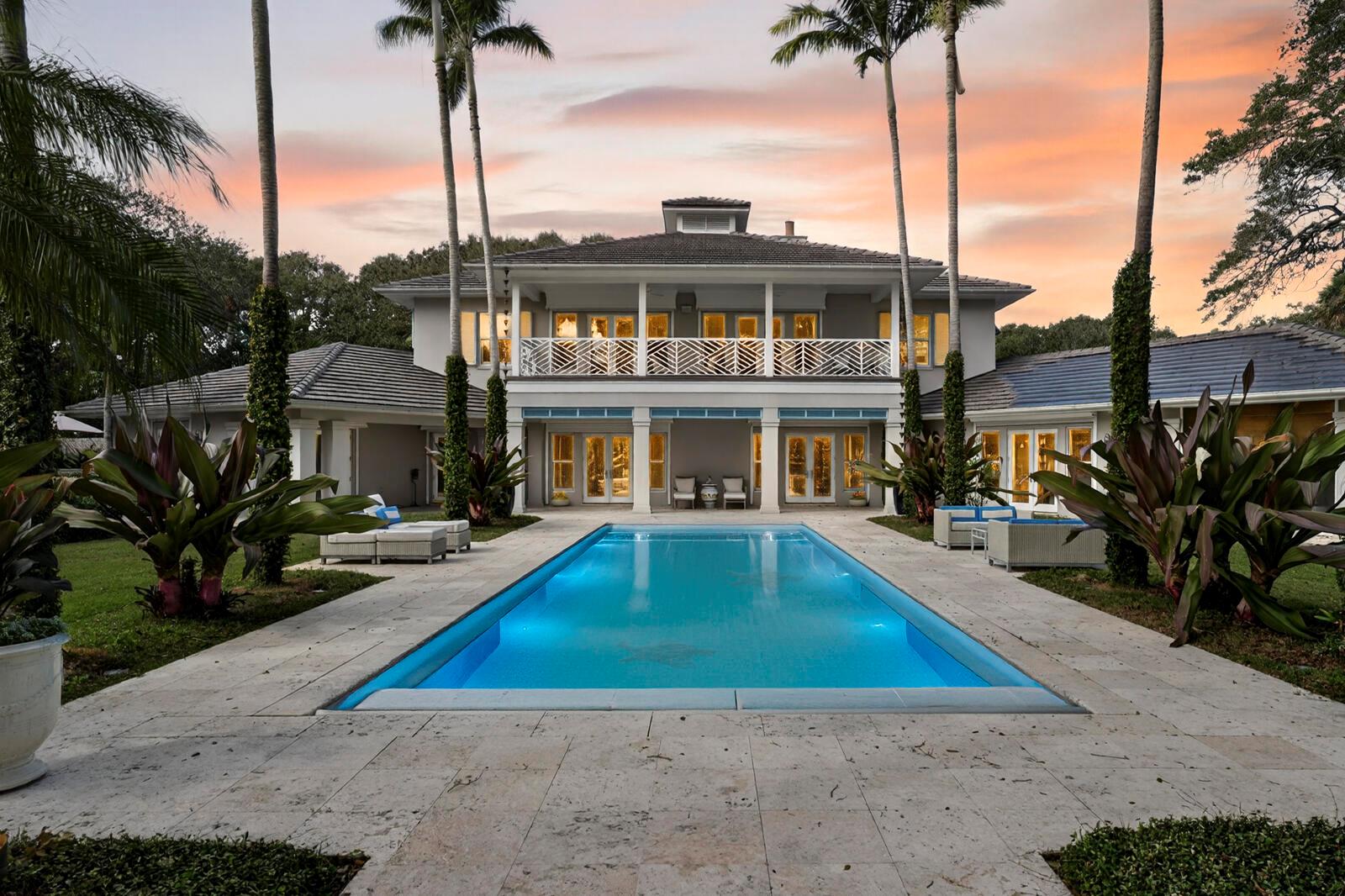 A two-story house with a balcony overlooks a rectangular swimming pool at sunset — 2010 Club Drive, Vero Beach FL 32963, VERO BEACH, FL