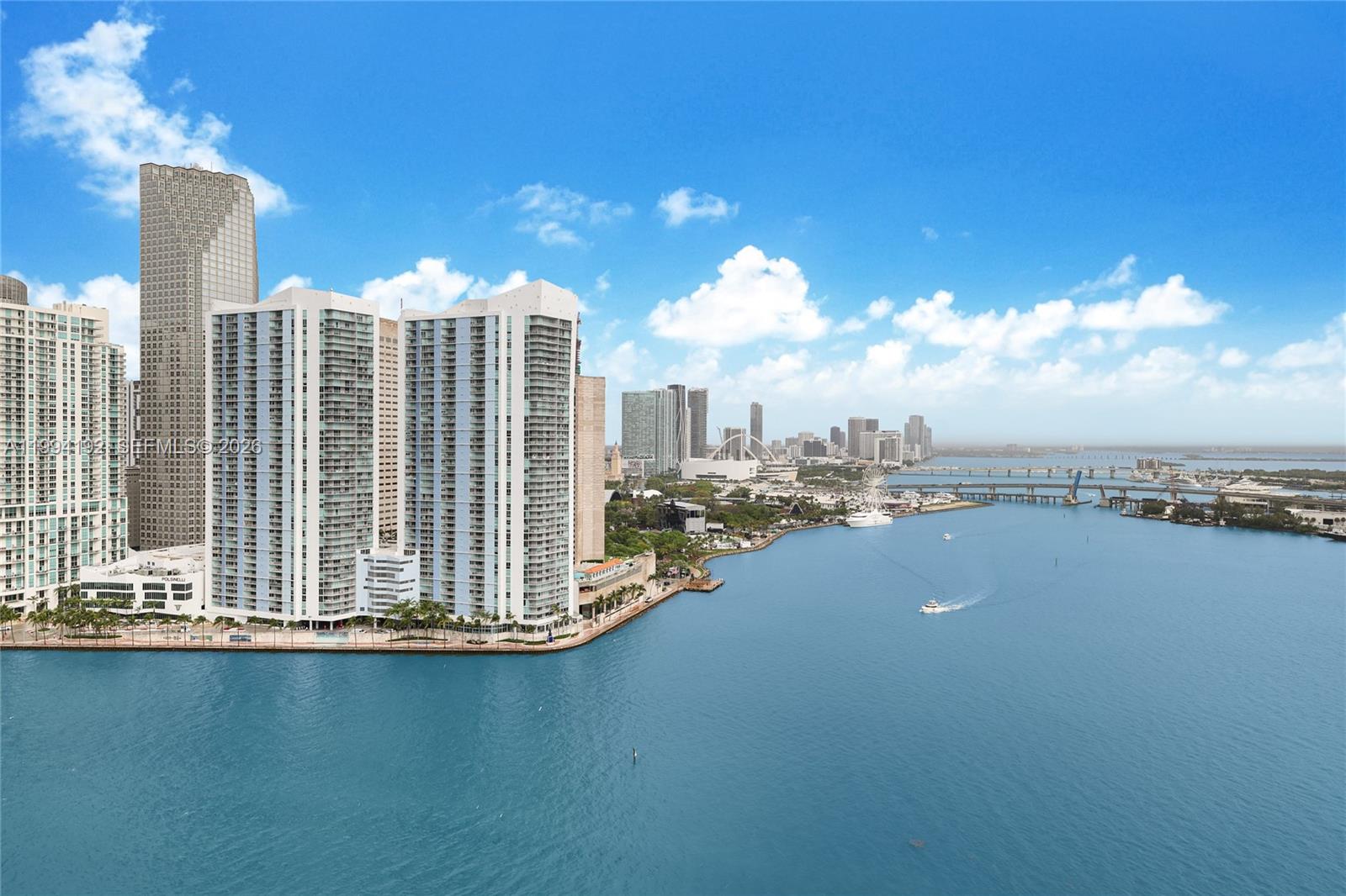 An aerial view of the Miami skyline featuring waterfront high-rise buildings and a bridge — 848 Brickell Key Dr # 2702, Miami FL 33131, MIAMI, FL