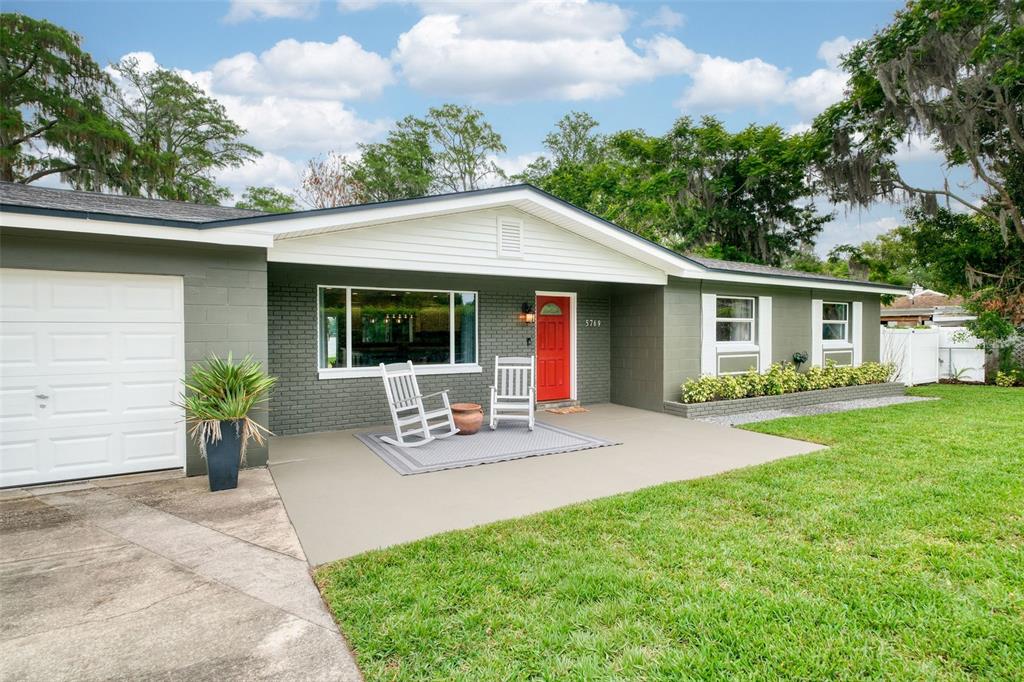 A living room features a sectional sofa, a television console, and sliding glass doors to a yard — 5769 ROCKWOOD AVENUE, ORLANDO, FL