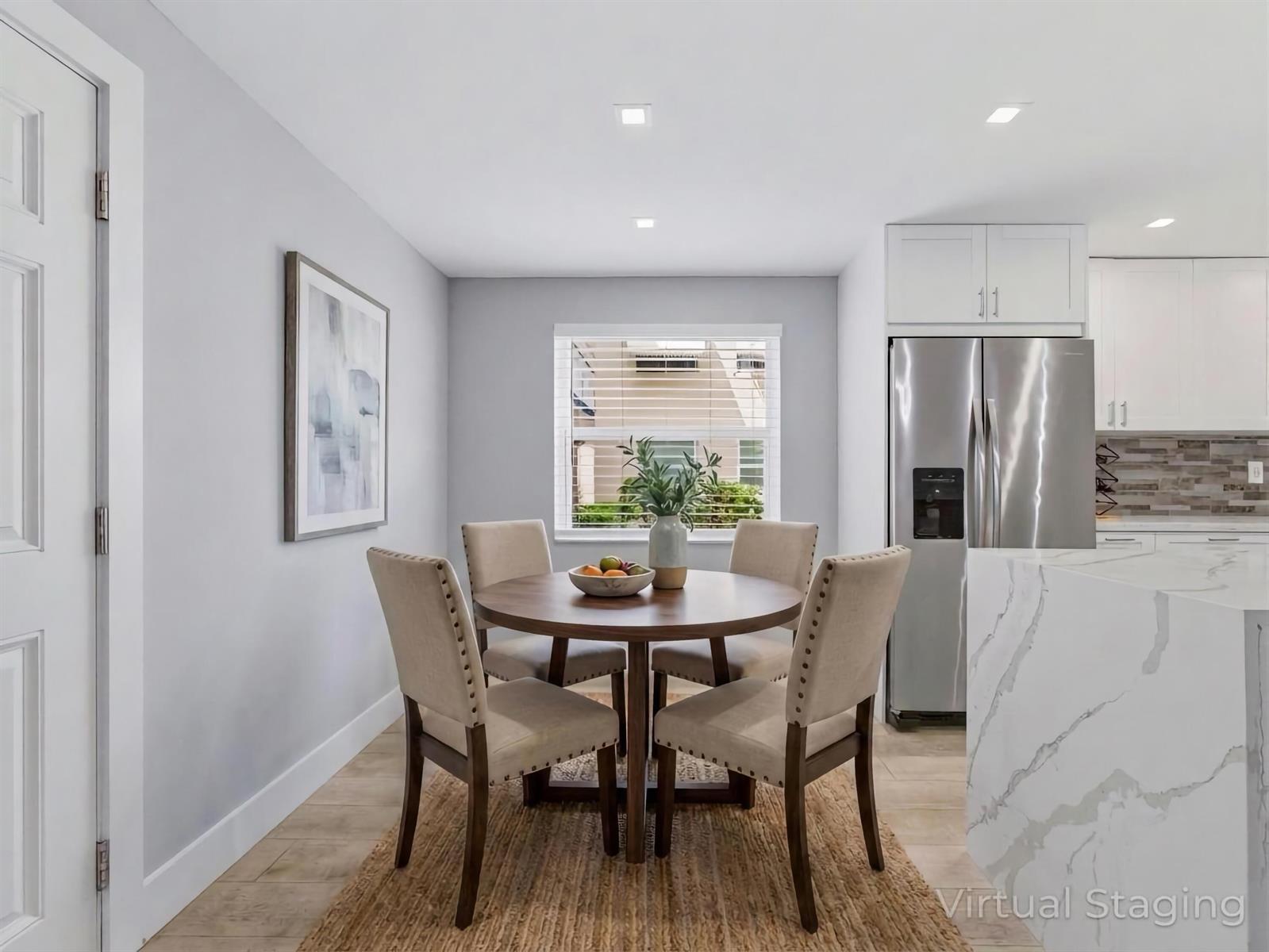 A dining area features a round wooden table, four upholstered chairs, and a jute rug — 397 Burgundy I, Delray Beach FL 33484, DELRAY BEACH, FL