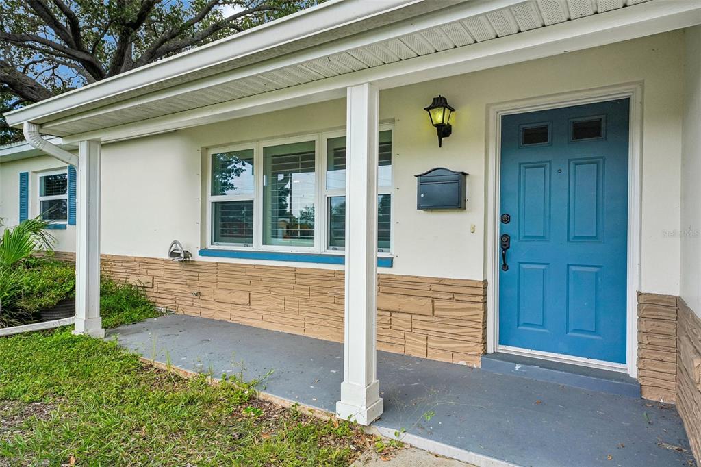 A front porch with a blue door, stone siding, and white columns on a house — 1500 39TH STREET N, ST PETERSBURG, FL