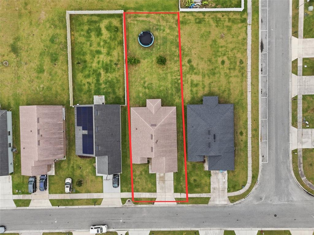 An aerial view shows a single-family home with a fenced backyard and a trampoline — 3640 GRUBBS STREET, MOUNT DORA, FL