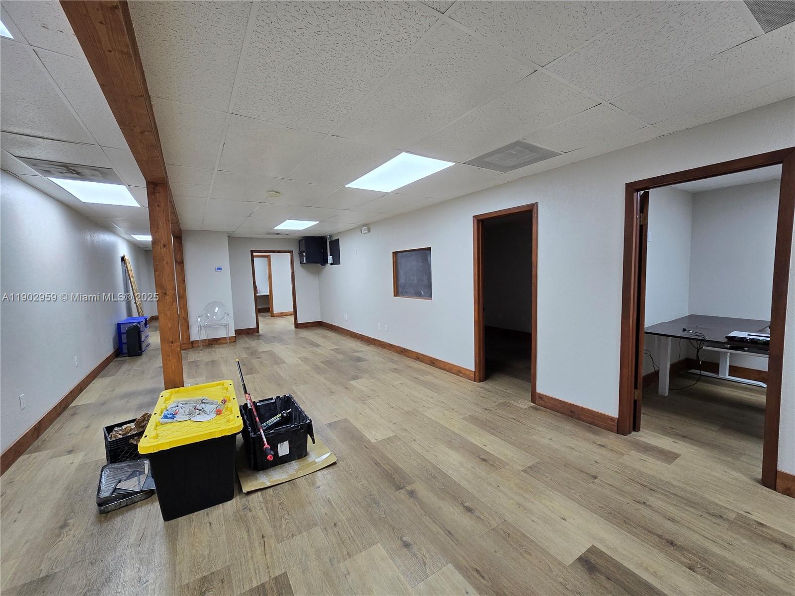 An office space features wood-look flooring, white walls, drop ceilings, and multiple doorways — 3580 NW 32nd St, Miami FL 33142, MIAMI, FL