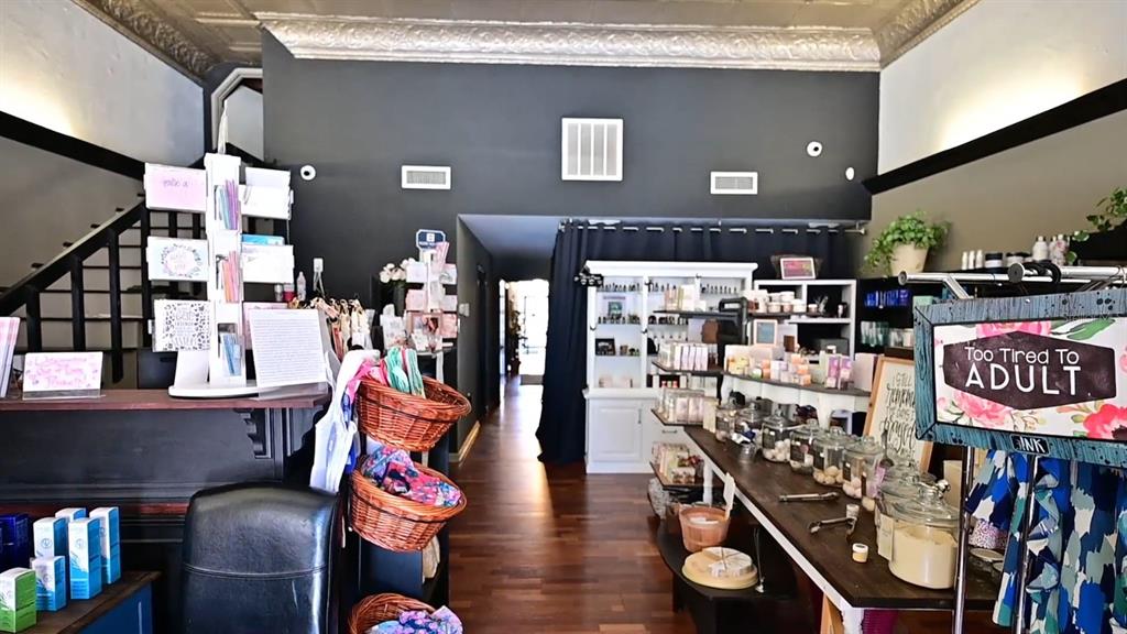 This retail shop features dark walls, wood flooring, display shelves, and a decorative tin ceiling — 245 E PARK AVENUE, LAKE WALES, FL