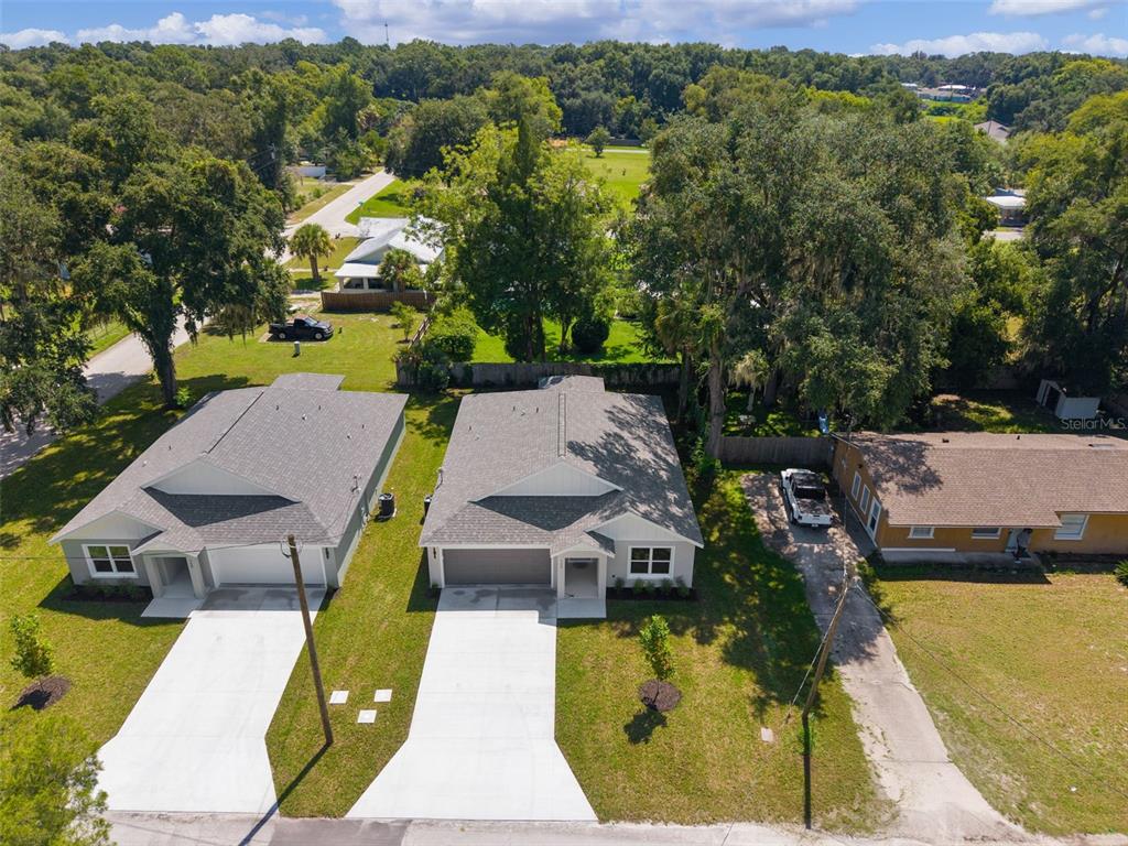 An aerial view shows two newly constructed houses with gray roofs and concrete driveways — 740 POWELL STREET, WILDWOOD, FL