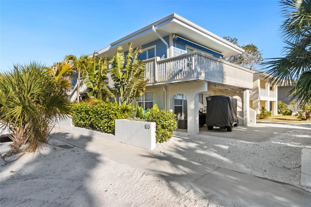 A two-story blue house with a white balcony and a covered parking area — 103 PALM AVENUE, ANNA MARIA, FL