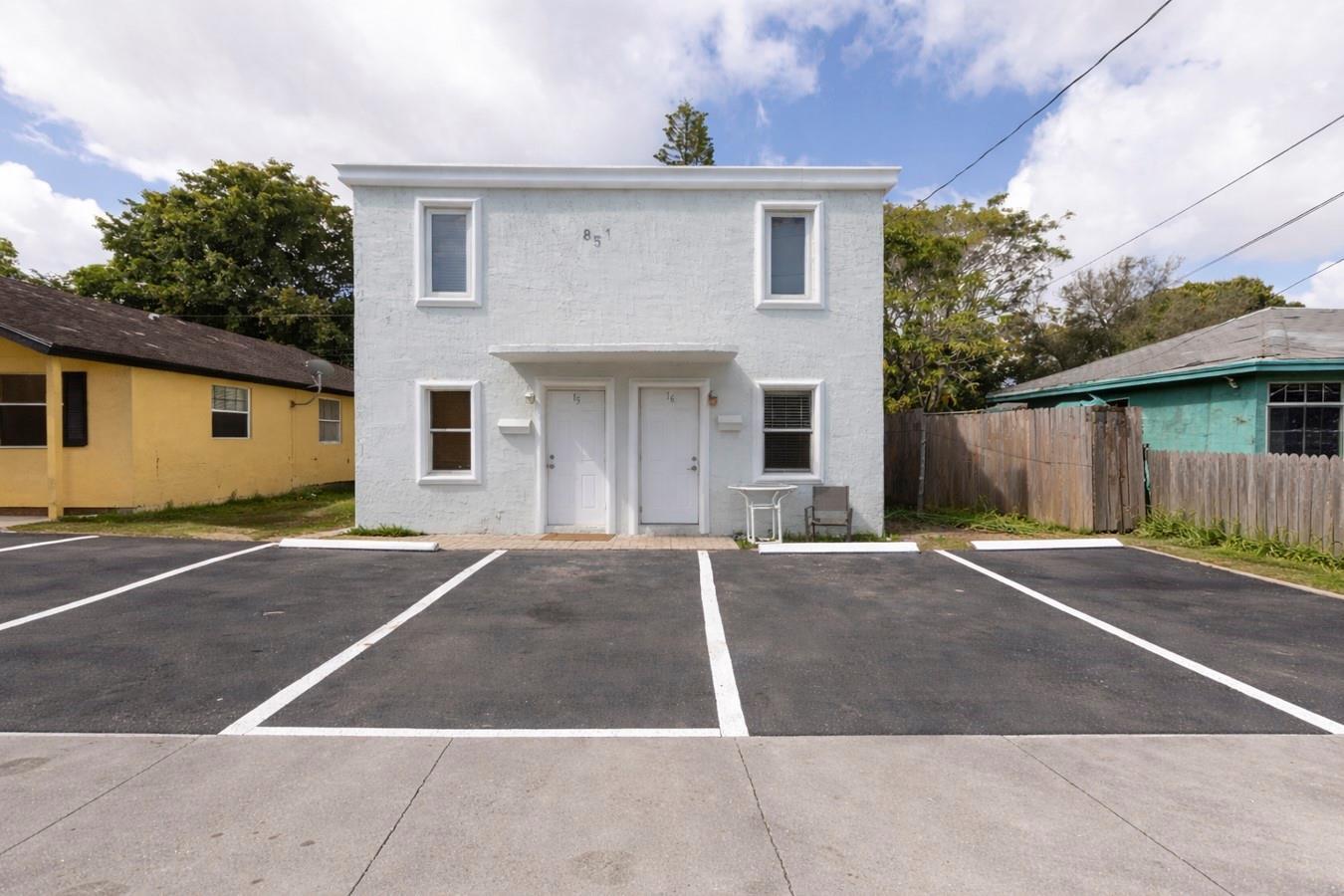 A two-story white stucco duplex features a paved parking lot in the front — 851 NW 4th Avenue, Pompano Beach FL 33060, POMPANO BEACH, FL