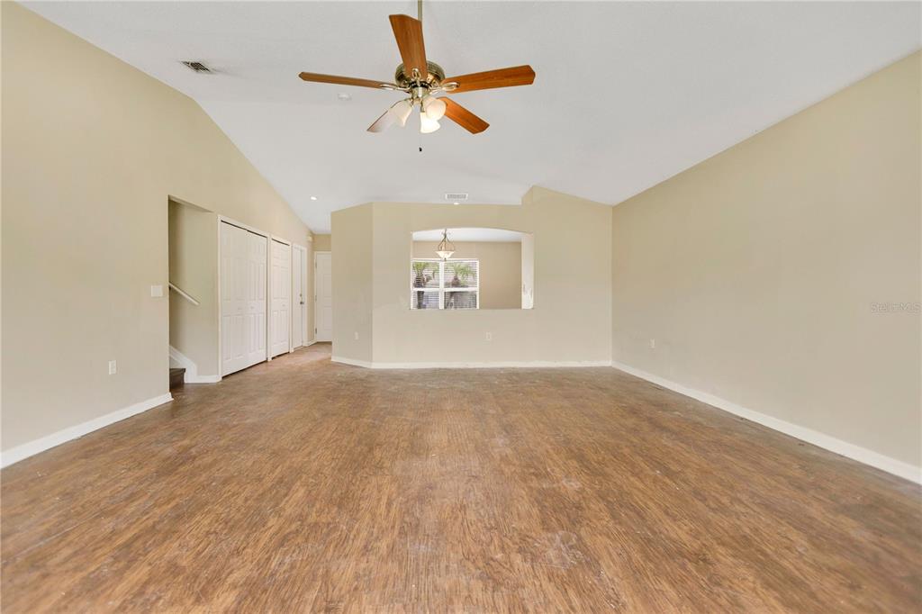 An empty room with wood-look flooring, a vaulted ceiling, and a ceiling fan — 3941 WARBLER DRIVE, WINTER HAVEN, FL