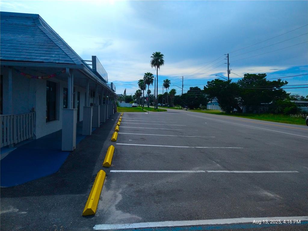 An exterior view shows a building with a covered walkway next to a paved parking lot — 6920,6922,6924,6926,6928 CLARK STREET, HUDSON, FL