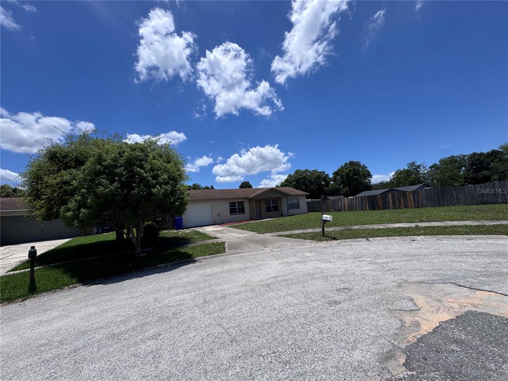 A single-story house with a garage and a large tree sits on a corner lot — 321 NOTHERN DURANGO AVENUE, OCOEE, FL
