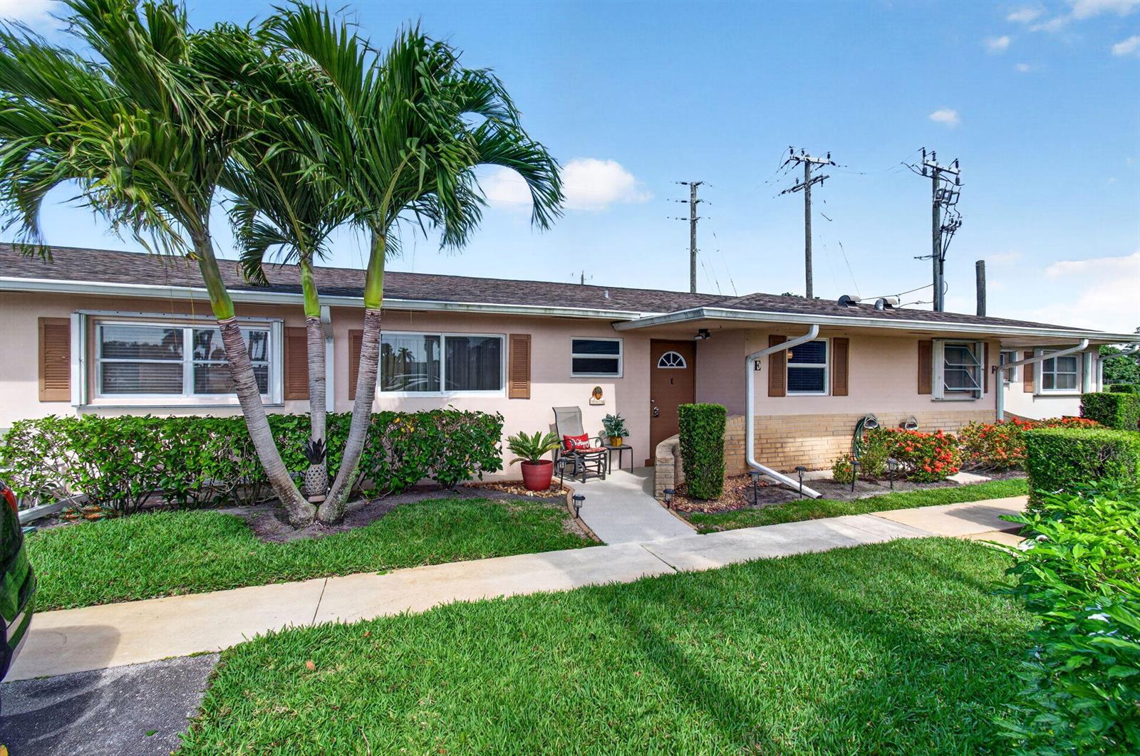 A single-story, light-pink residential building with a brown door, palm trees, and a front lawn — 2533 Dudley Dr, West Palm Beach FL 33415, WEST PALM BEACH, FL