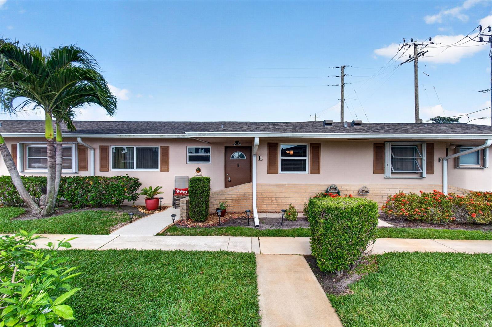 A single-story tan building with a brown door labeled E and a palm tree — 2533 Dudley Dr, West Palm Beach FL 33415, WEST PALM BEACH, FL