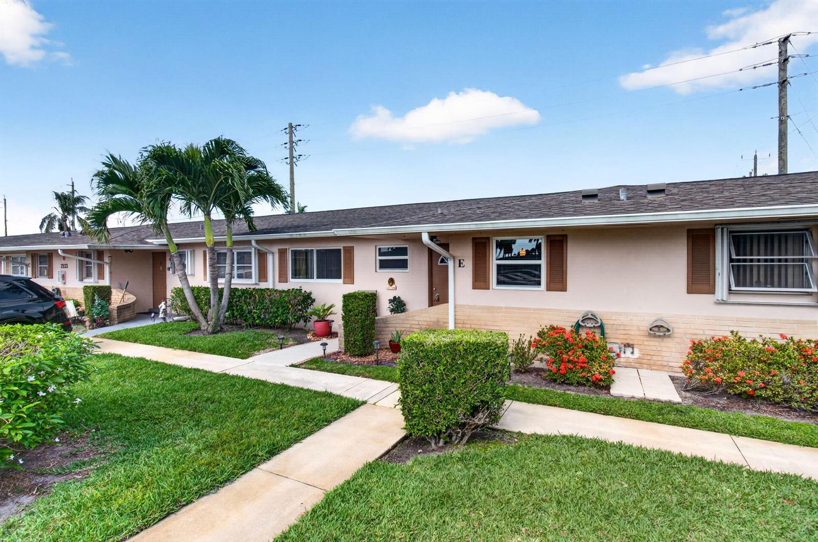 A single-story residential building with a tan exterior, brown shutters, and a landscaped front yard — 2533 Dudley Dr, West Palm Beach FL 33415, WEST PALM BEACH, FL