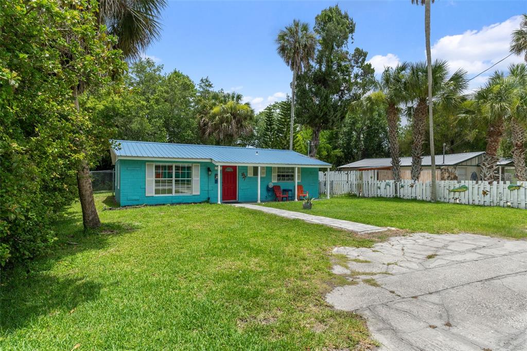 A turquoise house with a blue metal roof and a red front door — 7280 WIMBERLY COURT, WEEKI WACHEE, FL