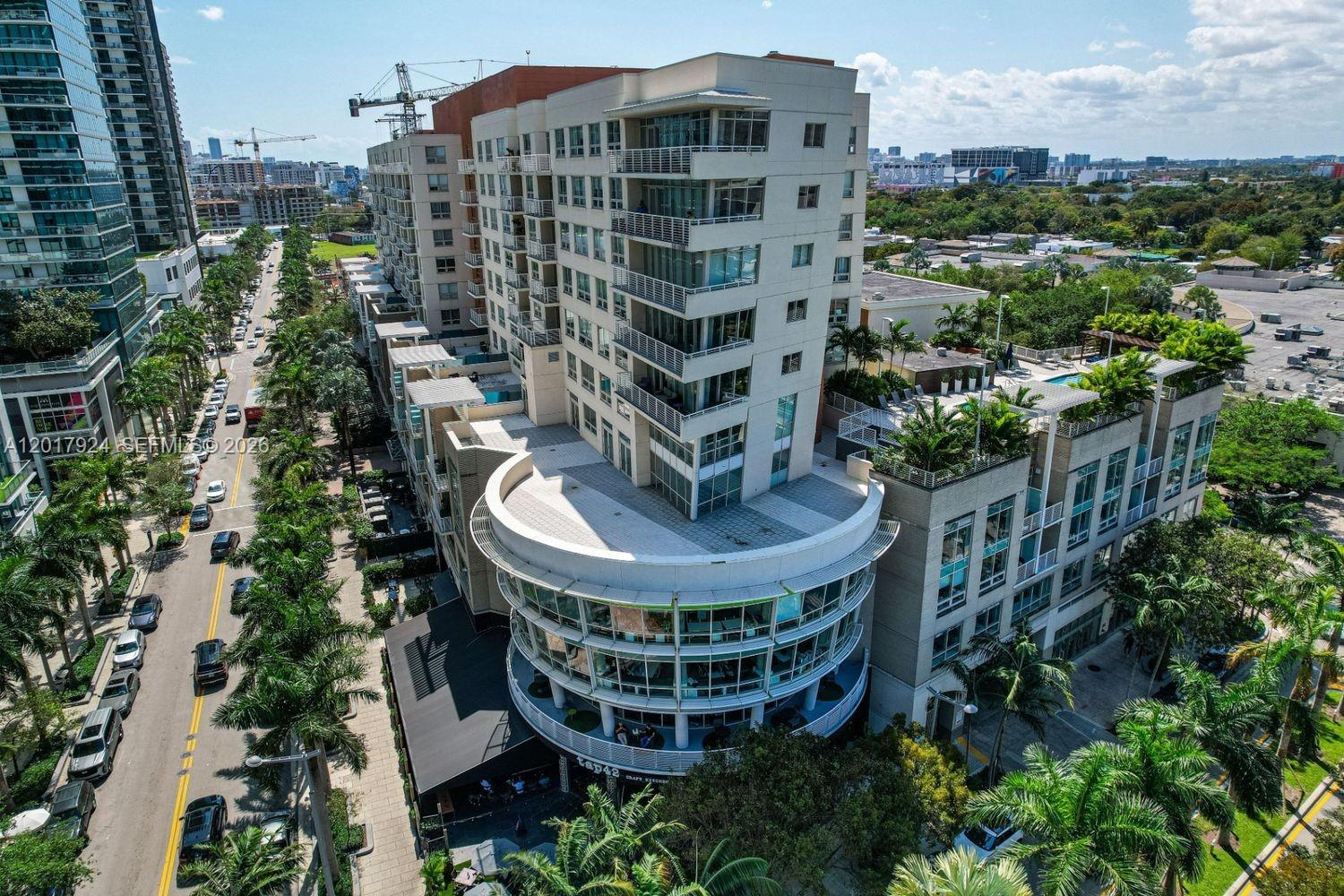 An aerial view shows a multi-story apartment building with a curved restaurant on the ground floor — 3250 NE 1st Ave # 916, Miami FL 33137, MIAMI, FL