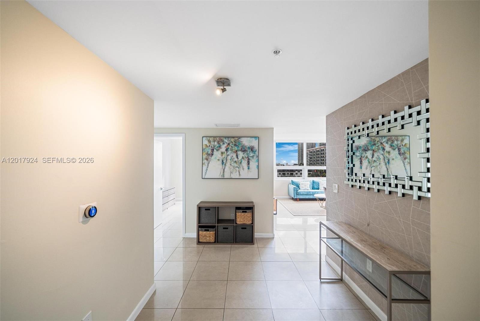 A tiled entryway leads to a living area with a mirror and storage unit — 3250 NE 1st Ave # 916, Miami FL 33137, MIAMI, FL