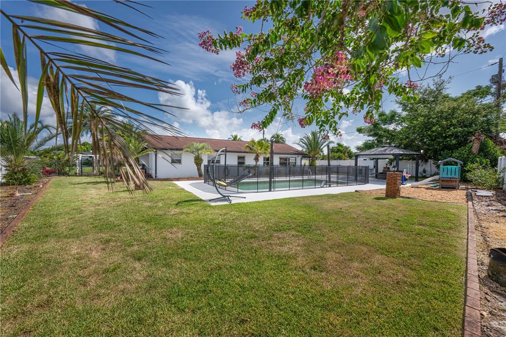 A single-story white house with a brick-paved driveway and palm trees in the front yard — 2826 AMBERGATE ROAD, WINTER PARK, FL