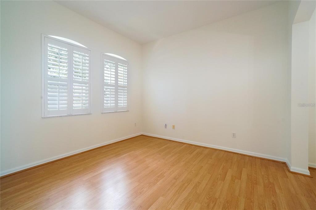 An empty room features light wood flooring, white walls, and two windows with plantation shutters — 974 KERSFIELD CIRCLE, LAKE MARY, FL