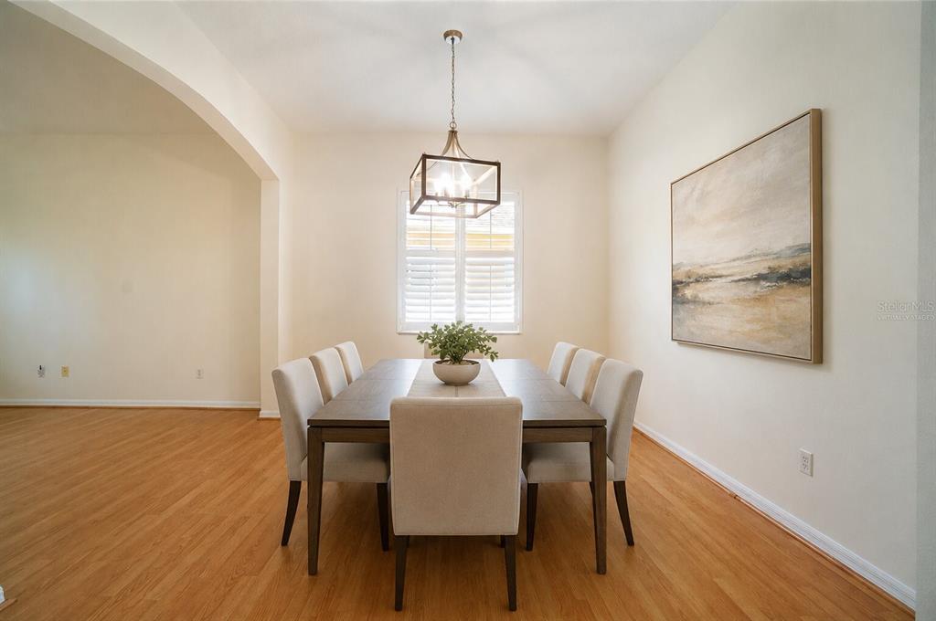 A dining room features a wooden table with six chairs, a chandelier, and wall art — 974 KERSFIELD CIRCLE, LAKE MARY, FL