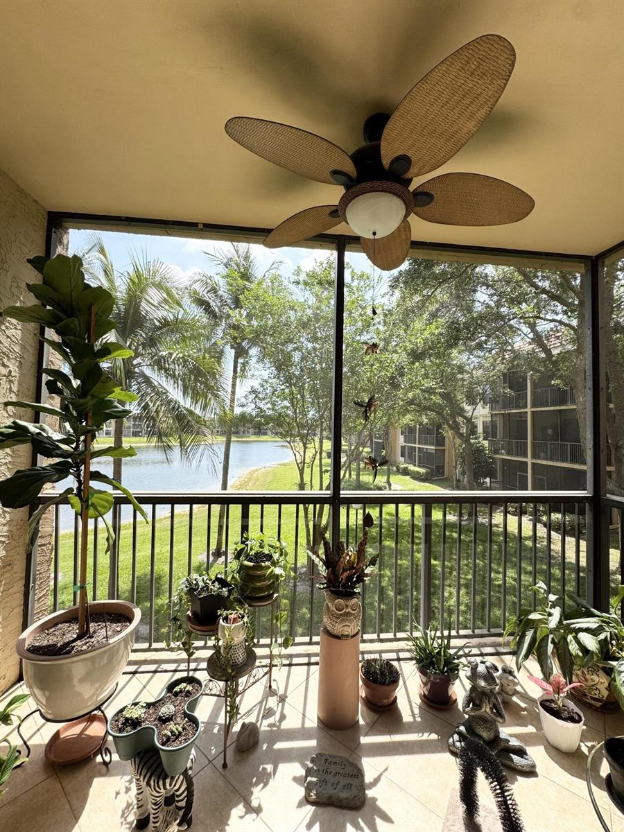 A screened-in balcony features a ceiling fan, potted plants, and a view of a lake — 6720 Coral Lake Drive # 6720, Margate FL 33063, MARGATE, FL