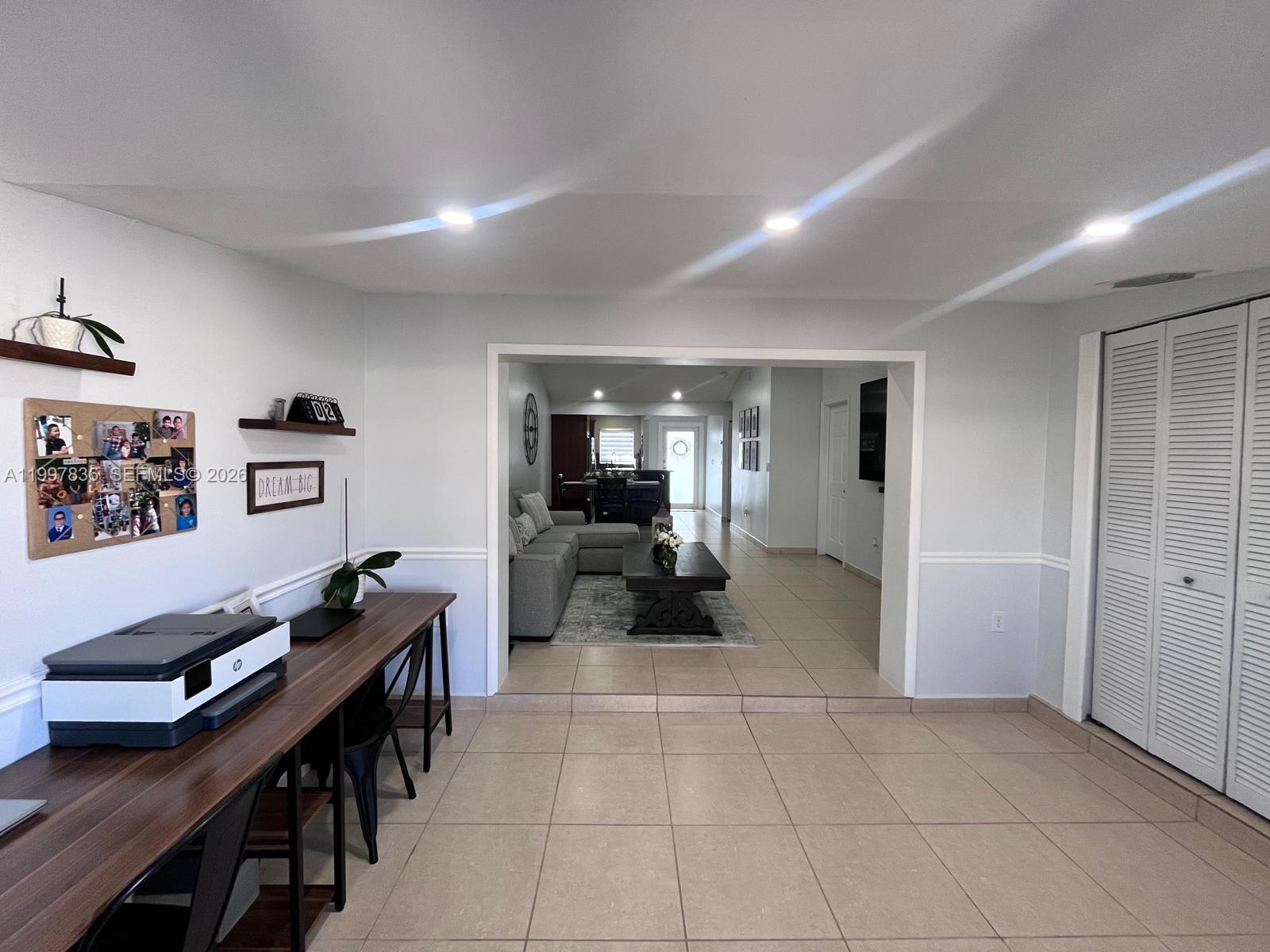 A room with a desk and printer opens into a living area with tile flooring — 4533 SW 143rd Pl, Miami FL 33175, MIAMI, FL