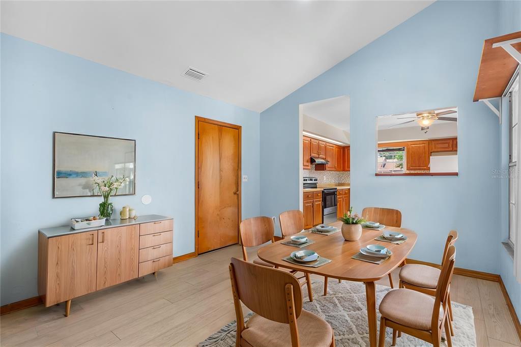 A dining room with light blue walls, wood furniture, and a view into the kitchen — 104 SHOAL CREEK CIRCLE, DAYTONA BEACH, FL