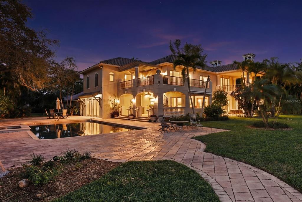 A two-story house with a pool, patio, and balcony at twilight — 6755 30TH STREET S, ST PETERSBURG, FL