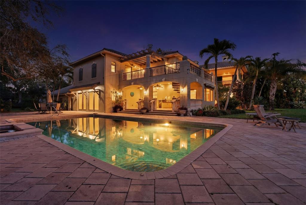A two-story house with a pool, patio, and balcony at dusk — 6755 30TH STREET S, ST PETERSBURG, FL